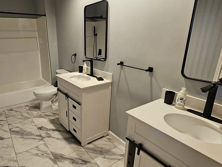 3rd bathroom upstairs has a tub/shower, 2 vanities, a storage closet behind the door
