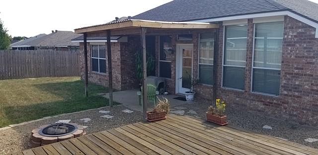 Covered back patio with deck and fire pit.