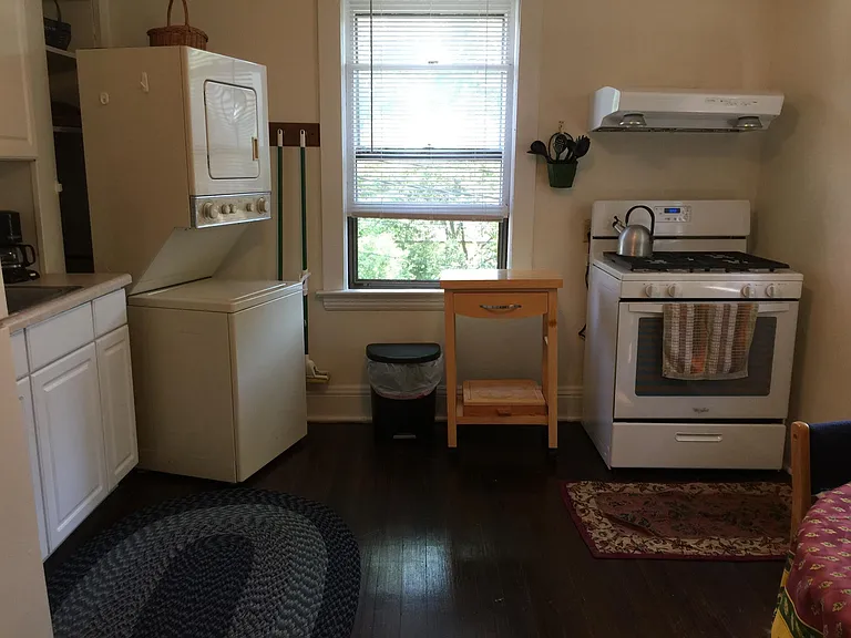 Kitchen showing sink, cabinet, washer/dryer and cooking range/hood