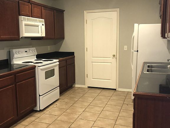 Kitchen has lots of cabinets & drawers. Appliances include refrigerator, range, microwave,dishwasher