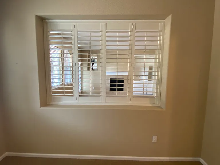Den/office with plantation shutters looking into living room