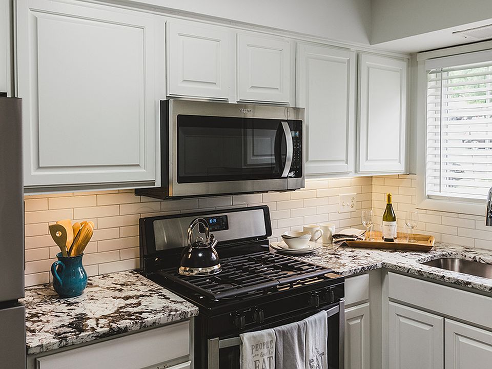 A modern white subway tile backsplash and matching white cabinets adorn our renovated homes