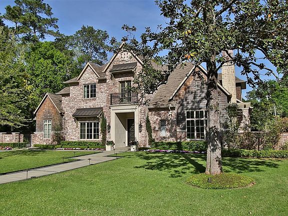Elegant stately side elevation. Reclaimed brick home with cedar accents. Juliet balcony above front door and gas carriage lights at grand entrance.