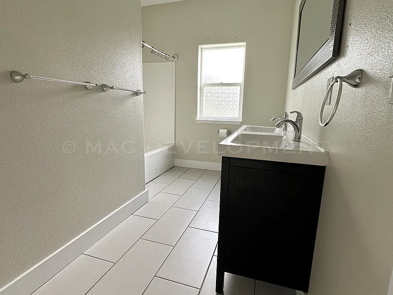 Second Bathroom includes tile floor, double sinks, bathtub and shower.