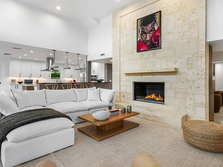 Stone-lined fireplace anchors a modern living space with soft textures and polished finishes.