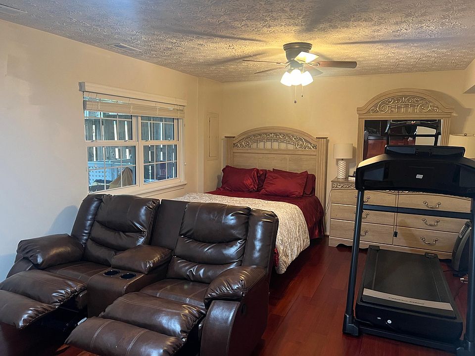 Basement Bedroom #4 with Roku 65" 4k HDTV, Double Recliner Sofa, Treadmill, Queen Bed, Dresser and Mirror
