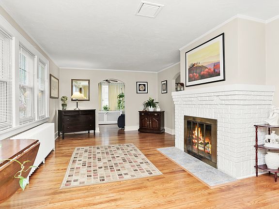 Large and open Living Room. The Sunroom beckons through arched doorway at the back.