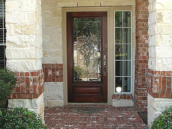 COVERED FRONT ENTRY IS ENHANCED WITH AUSTIN STONE AND BRICK...