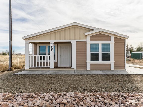 Nice covered deck, concrete walk around to large side patio!  Great for BBQ or hanging outside. 2x6 construction, upgraded insulation, Low-E vinyl windows.  Ground set with concrete block foundation.