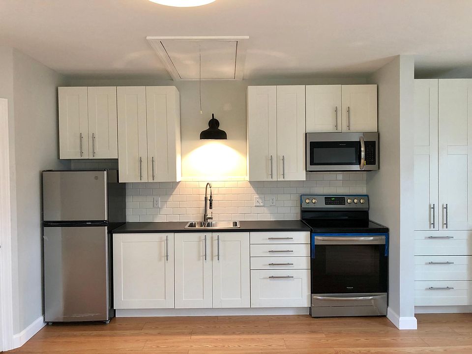 Compact kitchen with appliances provided. Wardrobe closet to right.