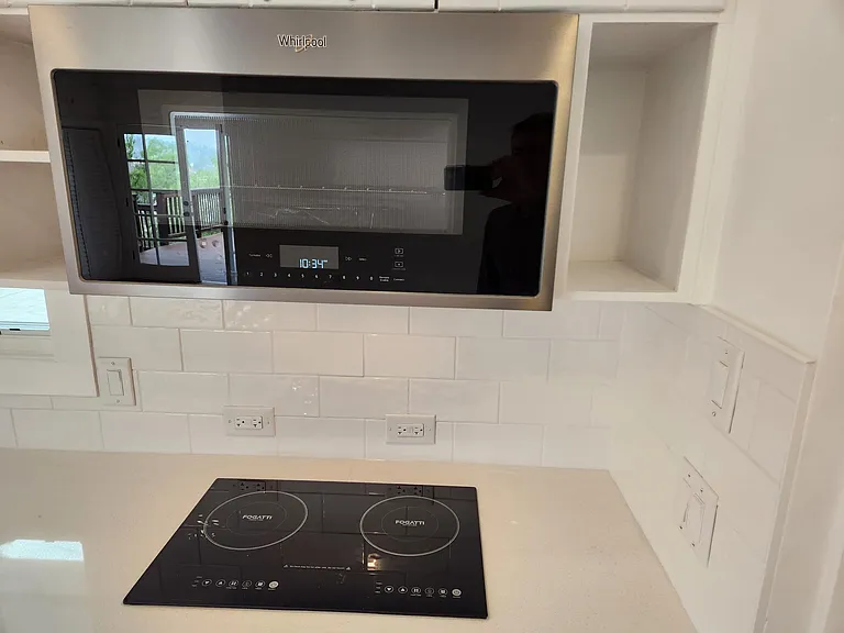 Large convection/microwave along with induction cooktop and quartz countertops.