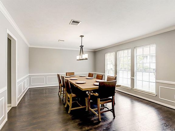 There is a Formal dining room with crown molding, triple window and updated light fixture. Wood floors and fresh classic grey paint.