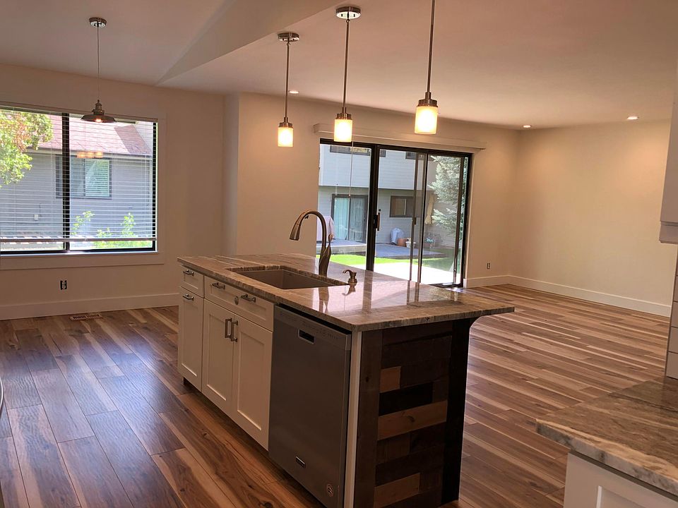Kitchen view of open living room w/sliding door to ground level wood deck.