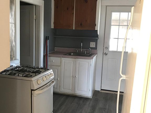 Kitchen with gas stove and brand new flooring.
