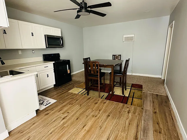 Open kitchen with ample cabinet storage, full appliance set, and an adjacent dining area with ceiling fan.