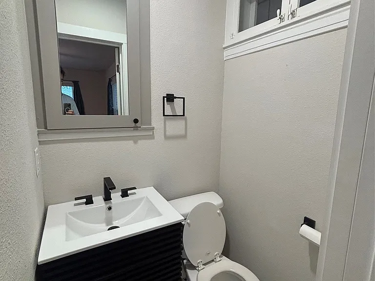 Modern vanity with a black reeded cabinet and integrated white sink