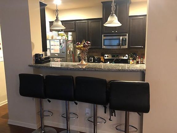 Breakfast Bar with Granite counter tops and Pendants lighting.