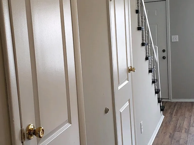 Another view of the Living Room, storage area door and the downstairs guest bathroom (1/2)