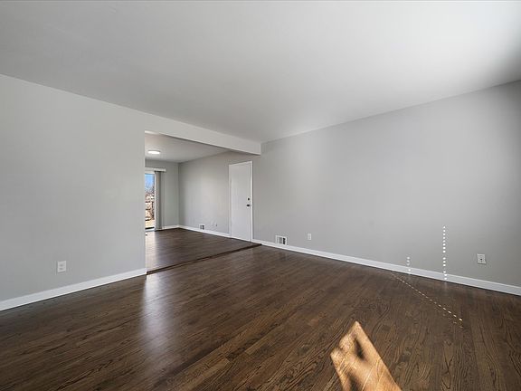 Spacious Living Room with fresh paint and refinished flooring