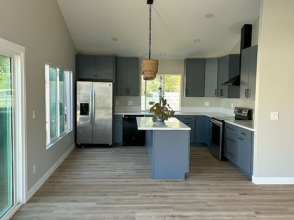 View to big new kitchen with island, dishwasher, refrigerator, and stove