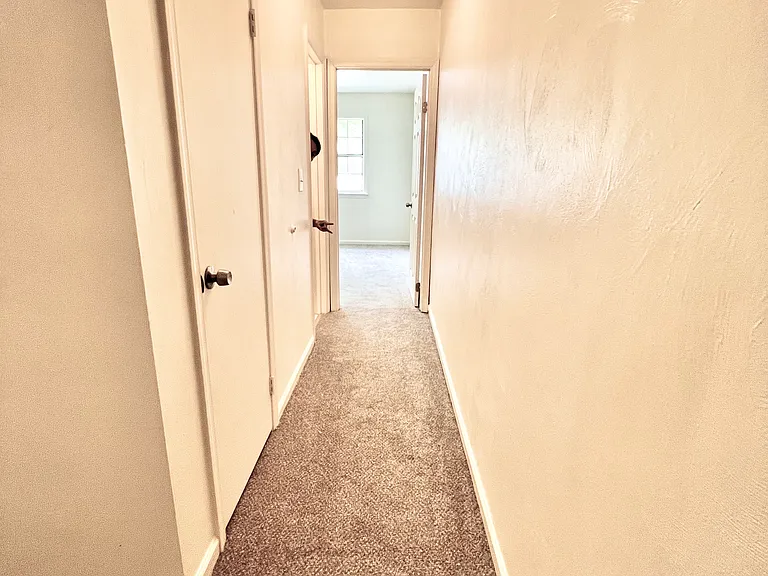 Upstairs hallway leading to Shared full bathroom and two other bedrooms