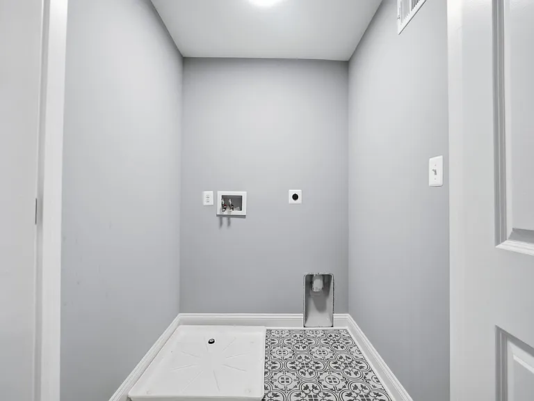 Large walk-in upstairs laundry with custom tile.