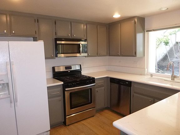 Kitchen with quartz countertops, stainless steel appliances, and recessed lighting.