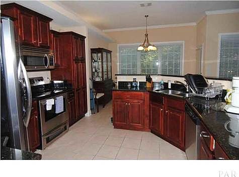 Warm and inviting home with cherry-stained cabinets, stainle