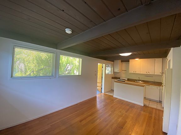 living room towards kitchen island, showing outlook from front windows.