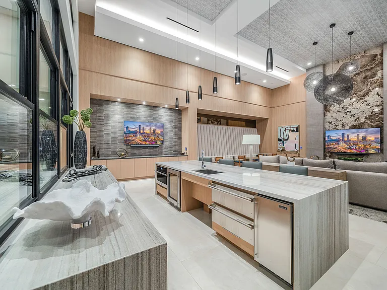 Luxurious open-concept living area featuring a modern kitchen island, elegant lighting, and cozy seating, perfect for entertaining.