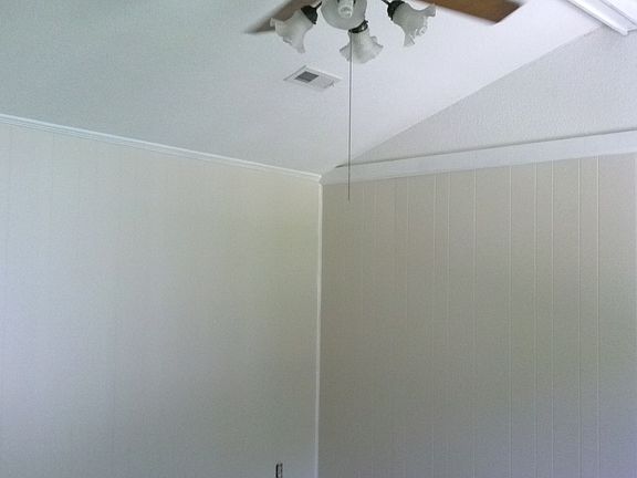 Vaulted Ceiling with lighted ceiling fan in Living room