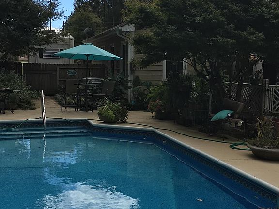 Large deck with secluded pool in back yard and tropical foliage