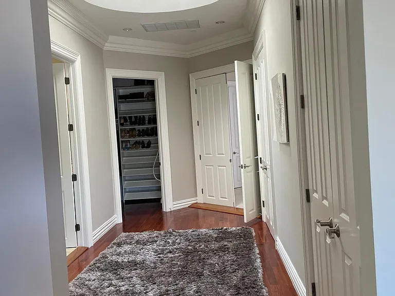 Primary suite hallway to walk-in closet and en suite bathroom