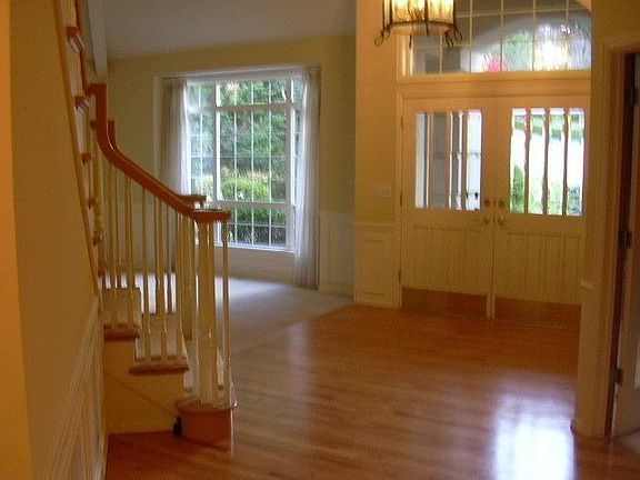 Entry from hall with double door, stairwell, and living room window