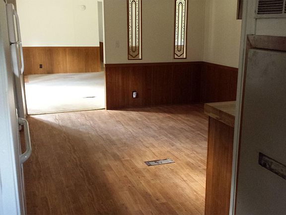 View from laundry room past stove and refrigerator across ki