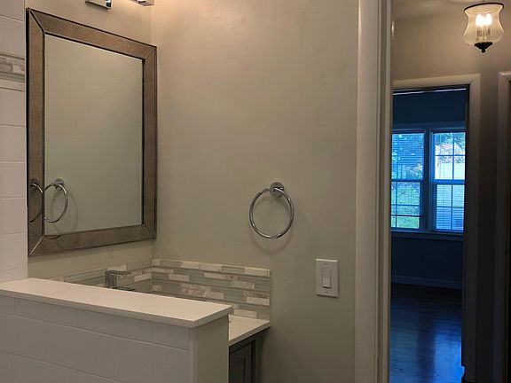 Beautifully remodeled upstairs full bath with tub/shower combination, white subway tile surround, grey maple cabinetry, tile/glass/marble accents, restoration hardware lighting....