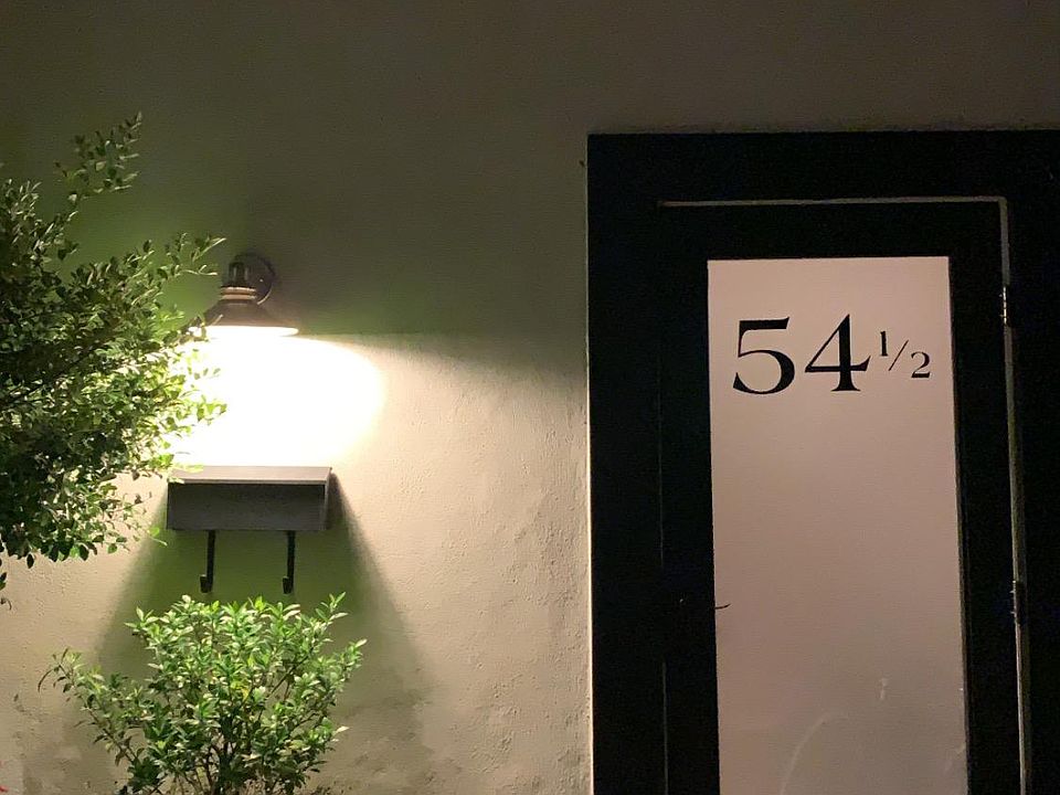 Exterior at night. The door is new! (We love it!) Your entrance is surrounded by a kitchen garden and features an iron table and chairs for your use.