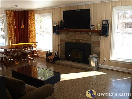 Large living room with 4 picture windows and concrete floors
