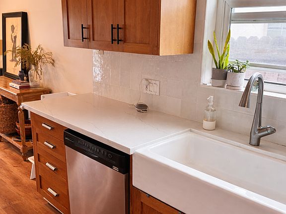 kitchen includes dishwasher, stovetop, oven, microwave, farmhouse sink