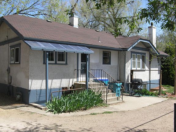 South side w/ patio, grill (included) and lower unit entrance.