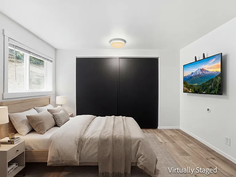 Primary bedroom staged with queen bed, and view of the closet