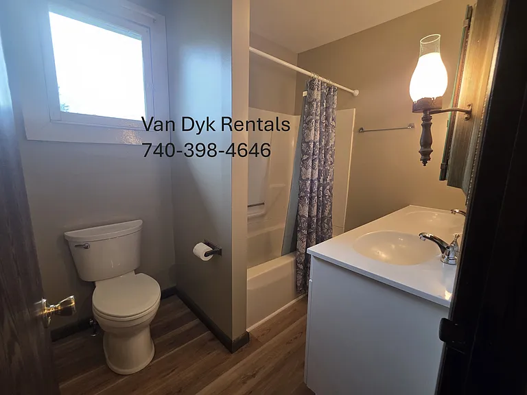 Full bath toward the back of the house with double sink, shower, tub, toilet.