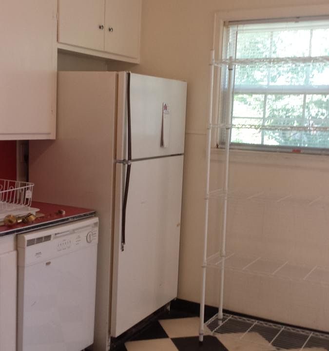 Kitchen with refrigerator and dishwasher. Door to back porch opposite refrigerator.