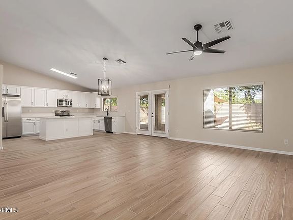 Step in to an open concept great room with new oak tile plank flooring, and soaring vaulted ceilings