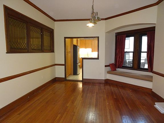 Dining room into Kitchen. Back patio visible through window and accessed from kitchen. Windows to left are decorative and face outside hallway.