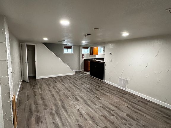 Large living room looking back toward kitchen which is on right. Storave under the stairs on the left.