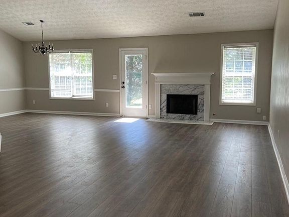 Open floor plan living and dining with marble surround fireplace