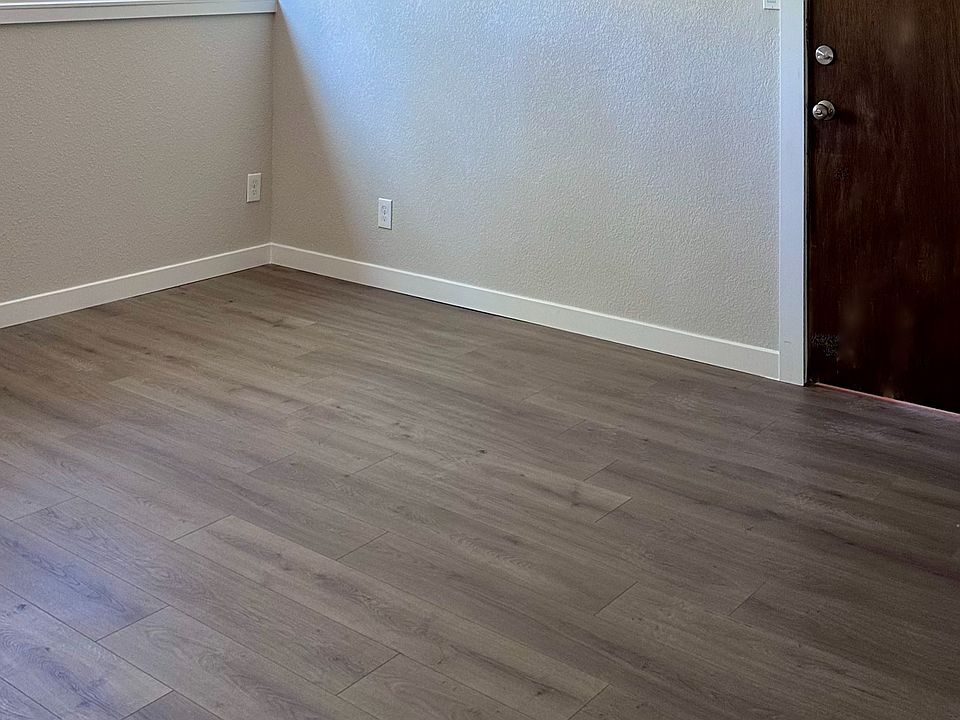 Bright living area with luxury vinyl plank flooring and ceiling fan.