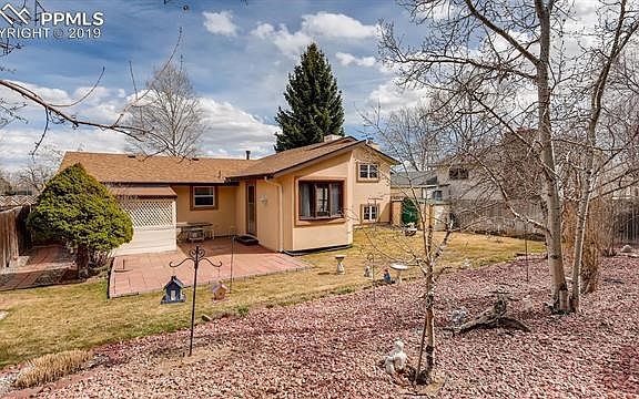 Spacious, landscaped yard with large paver patio and lattice covered area.