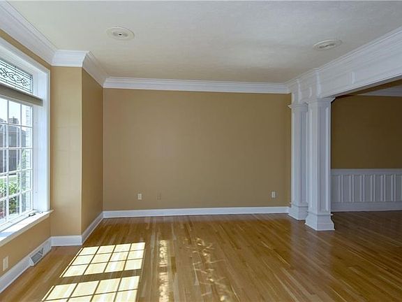 Living Room - Elaborate moldings, refinished hardwood floors, decorative pillars.